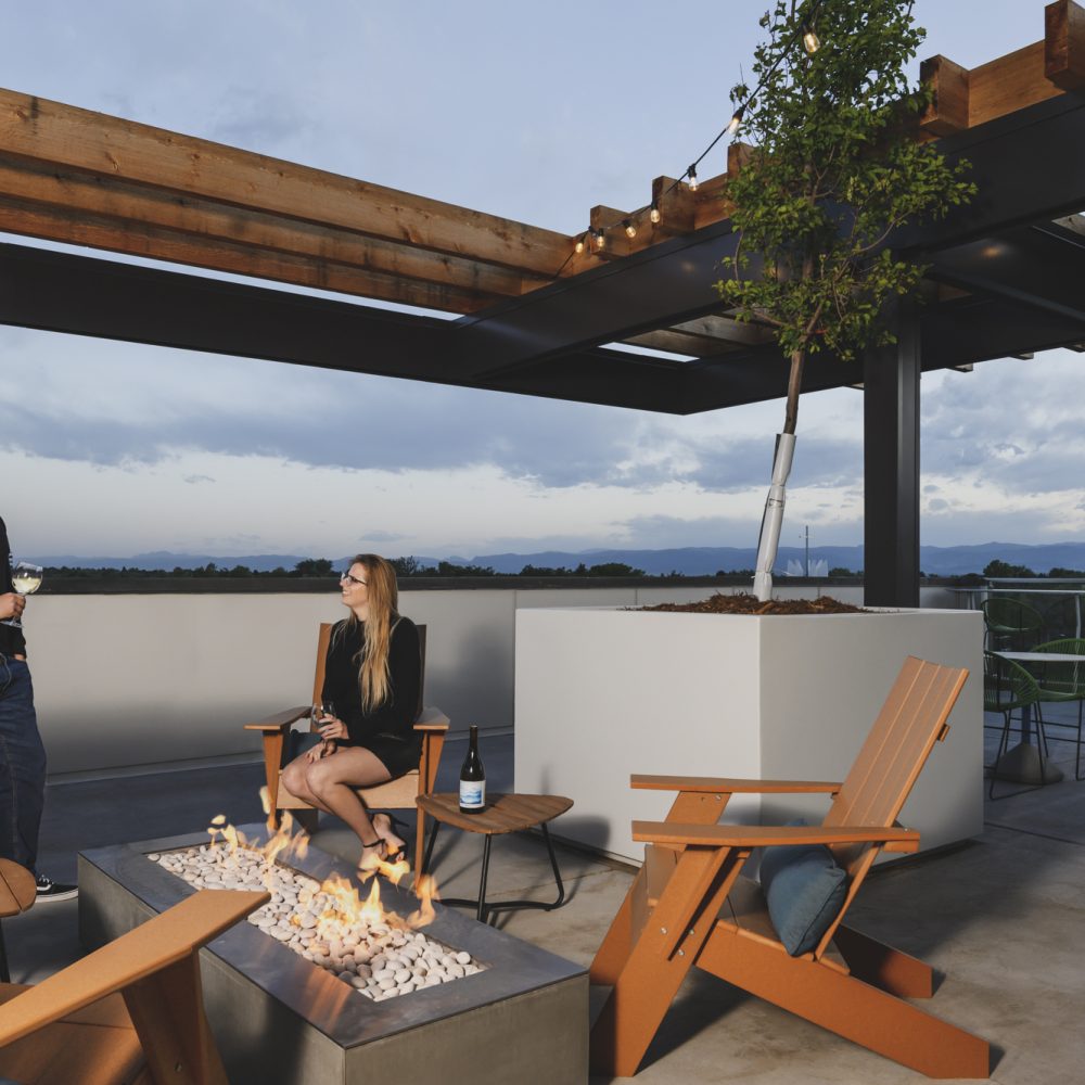 Denver, CO Luxury Apartments - DECO Apartments Rooftop Deck With Firepit, Lounge Chairs, and Gorgeous View of the Horizon