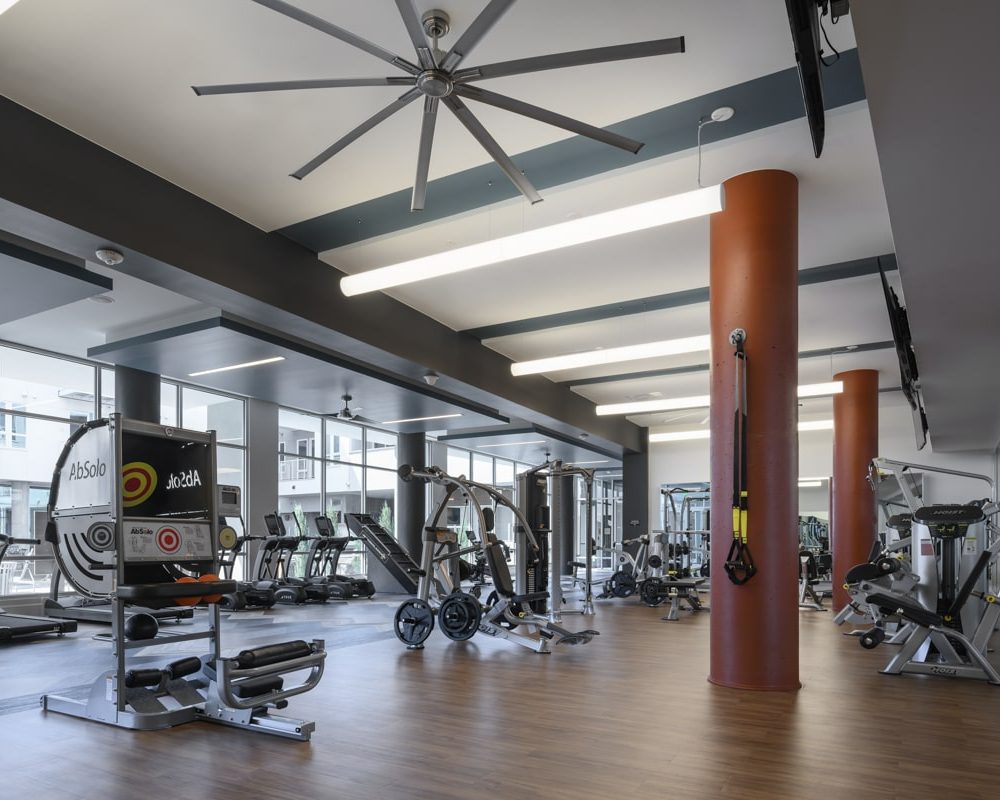 Apartments Denver, CO - DECO Apartments Fitness Center With Weight Machines, Cardio Machines, and TVs